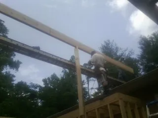 Carpenter setting a ridge beam over a new addition frame — Ice Dam Removal by Roofing Brothers in Port Washington