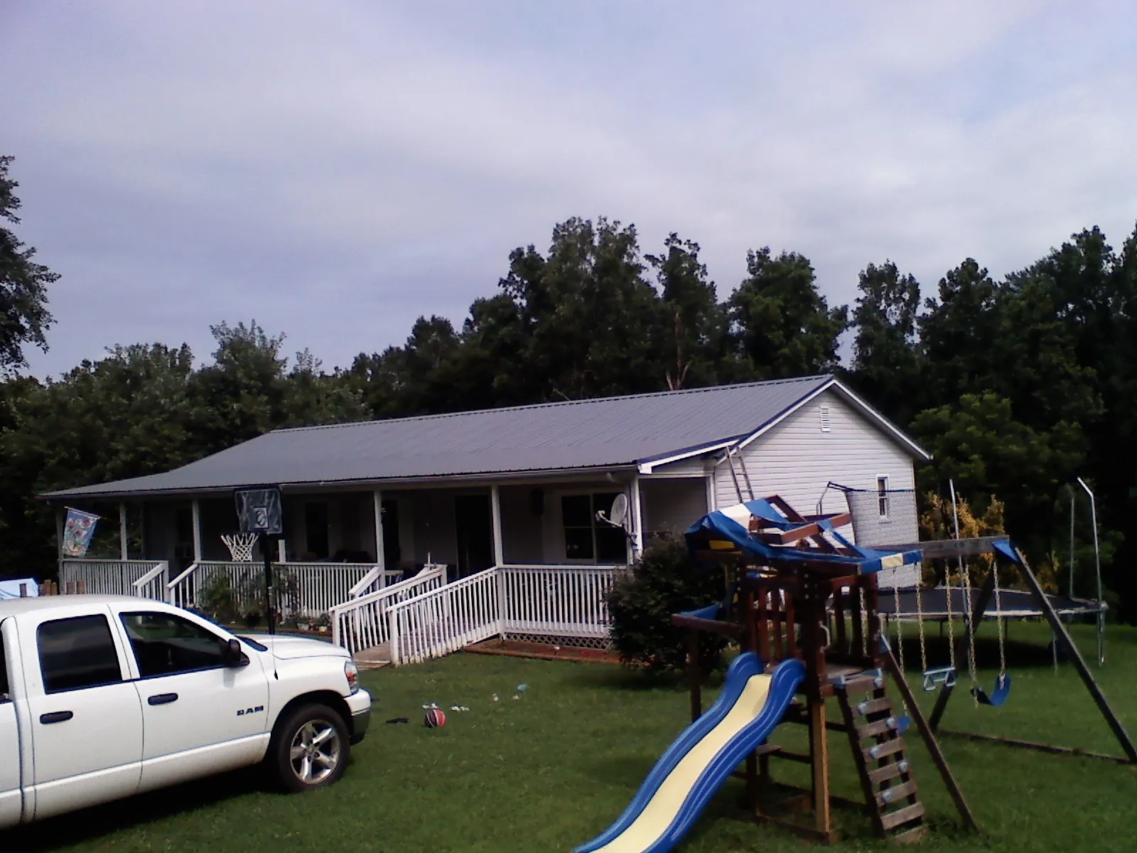 Dark metal roof on a country home with a full length front porch in Port Washington
